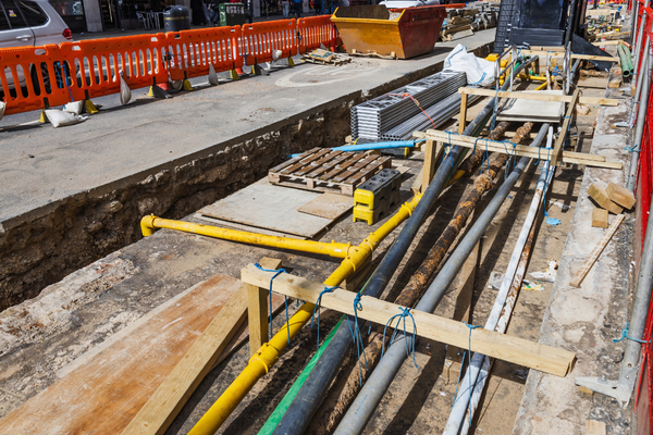 Detailed View of Construction Trench with Pipes and Cables Being Laid for Utility Services